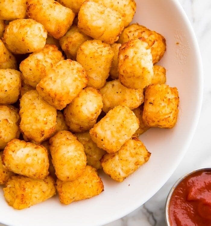Air fruer tater tots served in a bowl with sauce