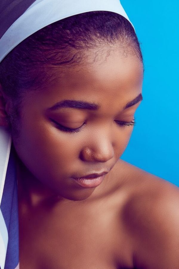 a girl with beautifully clear and smooth skin against a blue background