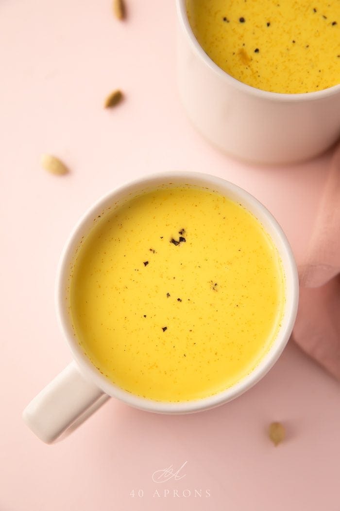 Close up of a yellow drink in a white mug