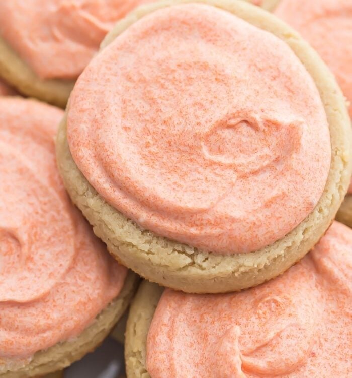 Pink iced cookies stacked on top of eachother
