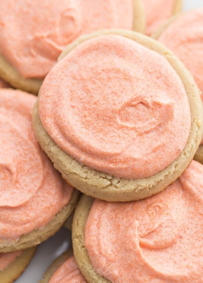 Pink iced cookies stacked on top of eachother