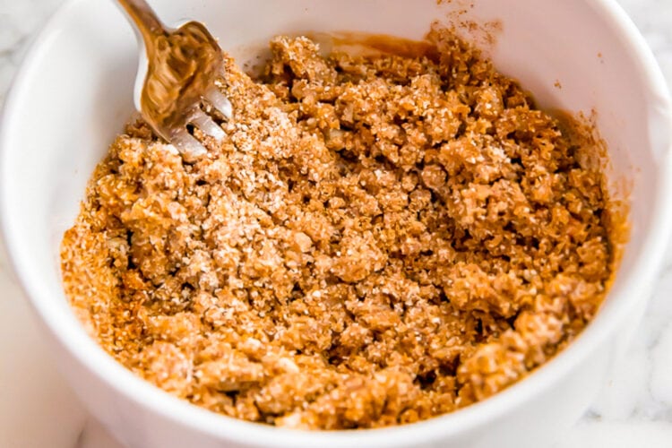 Pumpkin muffin crumb topping mixture in a small bowl with a fork.