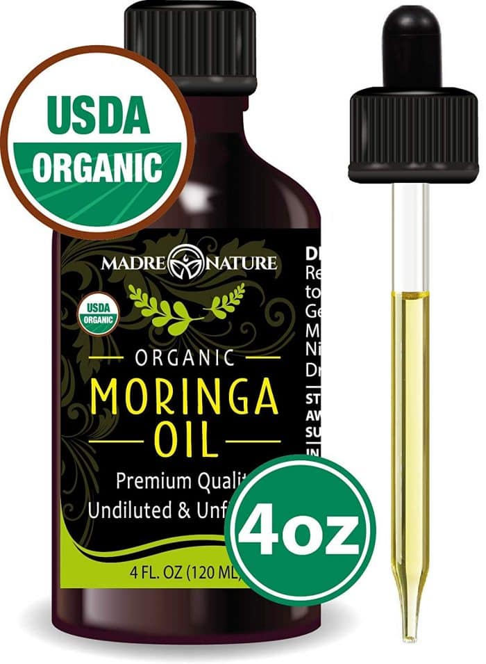 a small bottle of organic moringa body oil for dry winter skin against a white background 