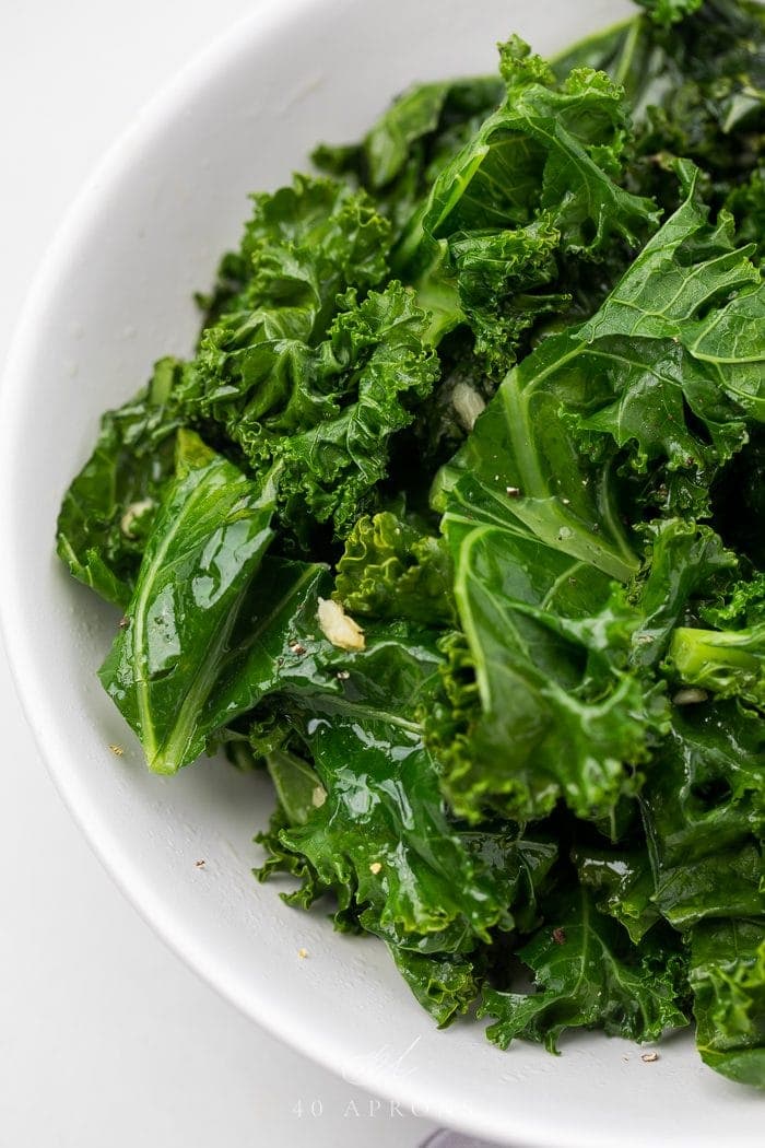 Close up of sauteed kale in a white bowl