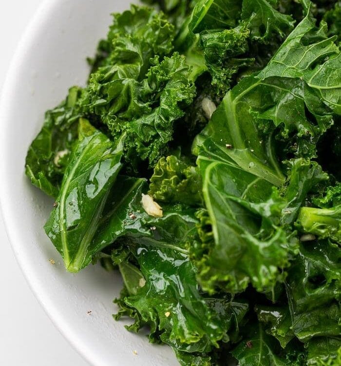 Close up of sauteed kale in a white bowl