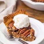 A slice of pecan pie with whipped cream