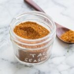 taco seasoning in a glass jar on a marble surface