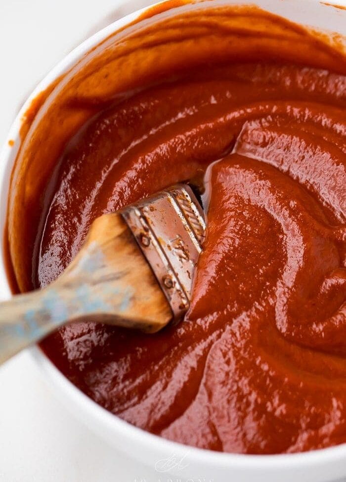 A bowl of the whole30 bbq sauce with a brush in it