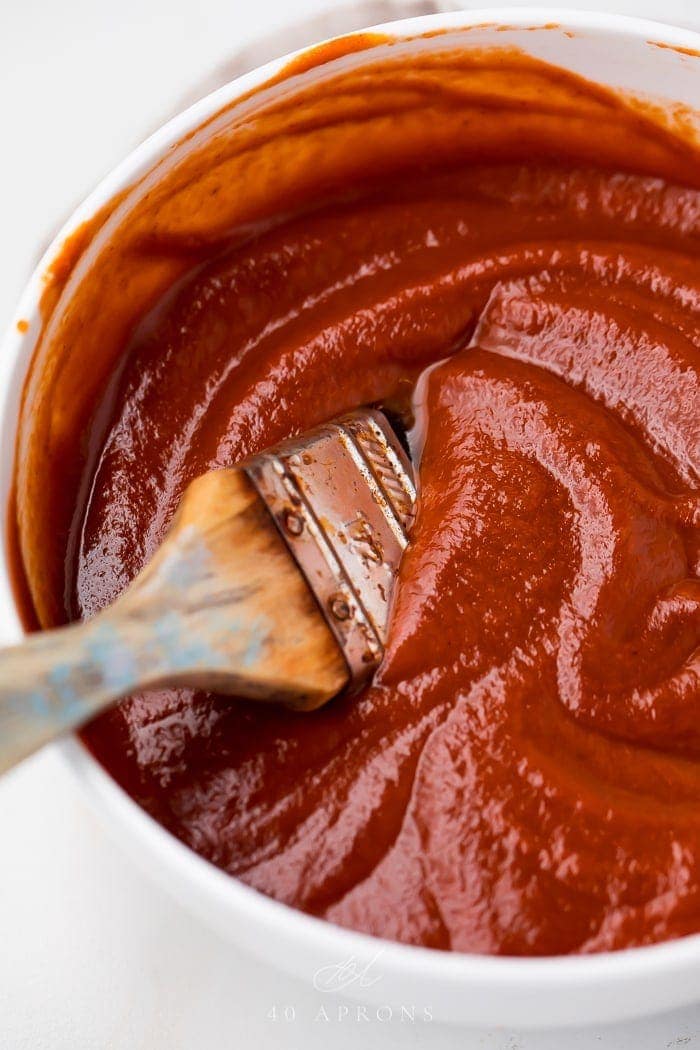 A bowl of the whole30 bbq sauce with a brush in it
