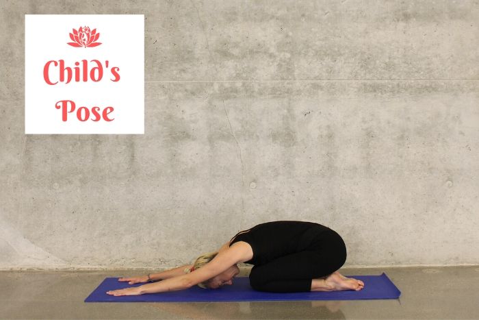 a woman holding the child's pose on a blue yoga mat to relieve holiday stress