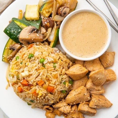 Hibachi chicken veggies and rice on a white plate