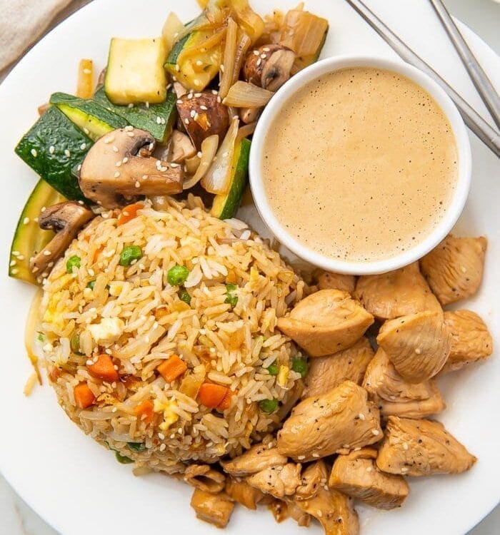 Hibachi chicken veggies and rice on a white plate