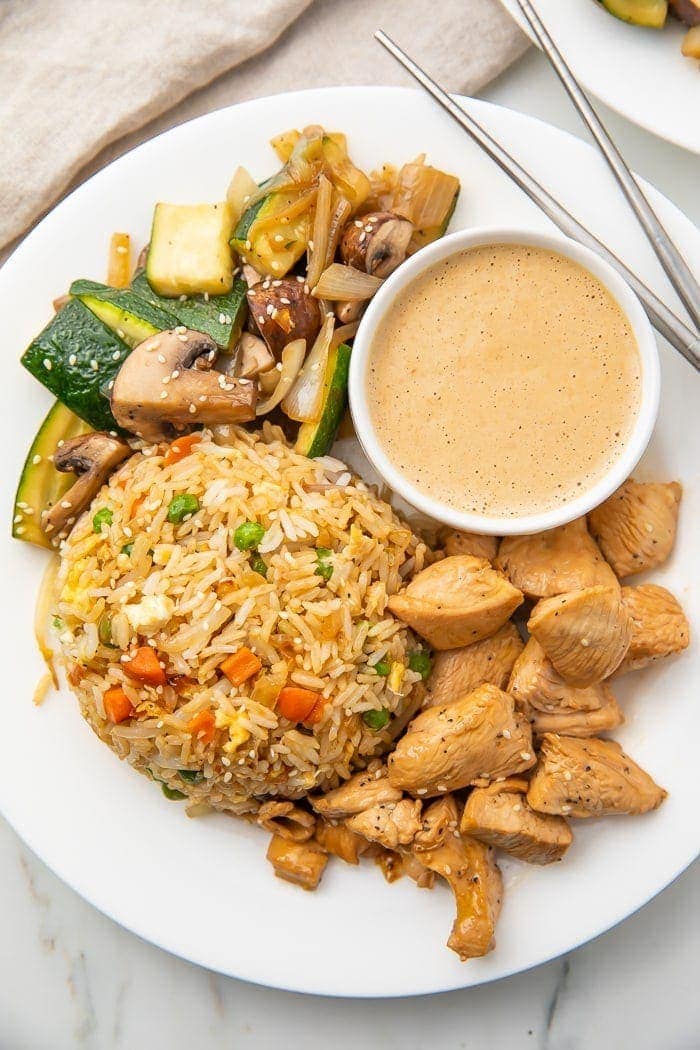 Hibachi chicken veggies and rice on a white plate