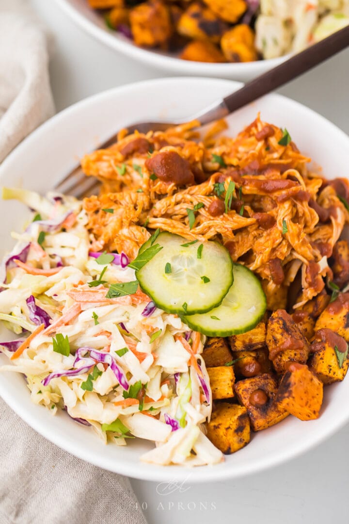 BBQ chicken bowl with sweet potatoes and coleslaw in a bowl