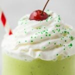 Close-up of healthy mint shake in a glass with whipped cream and a cherry