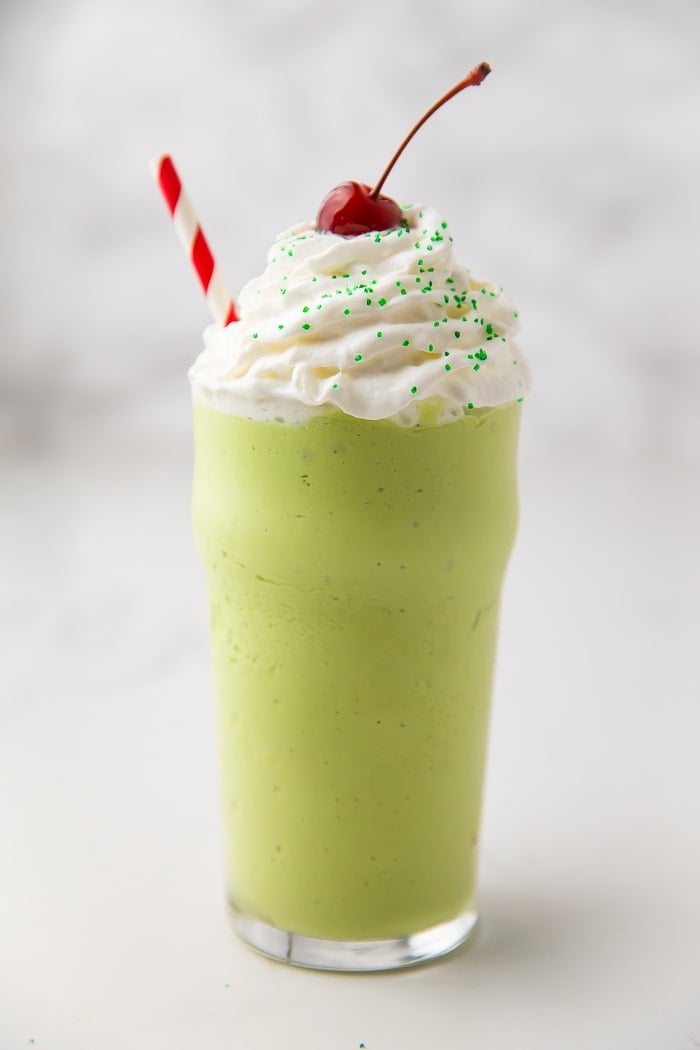 Healthy mint shake in a glass with whipped cream and a cherry