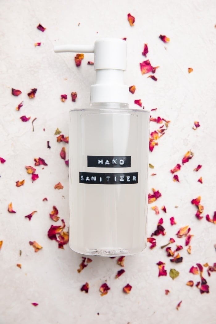 Homemade hand sanitizer recipe in bottle on dried rose petals