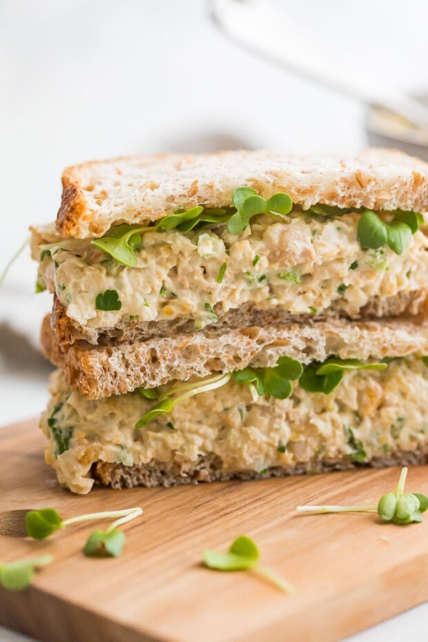 Chickpea salad sandwich cut in half, with one half stacked on top of the other