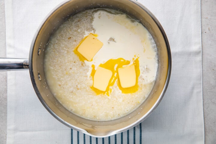 Simmered grits, 3 tablespoons butter, and a little heavy cream in a silver saucepan.
