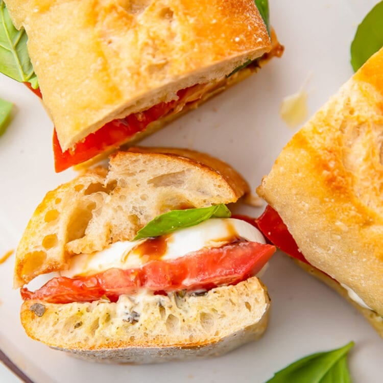 A cross section of a caprese sandwich, stood upright on one end to show the inside of the sandwich.