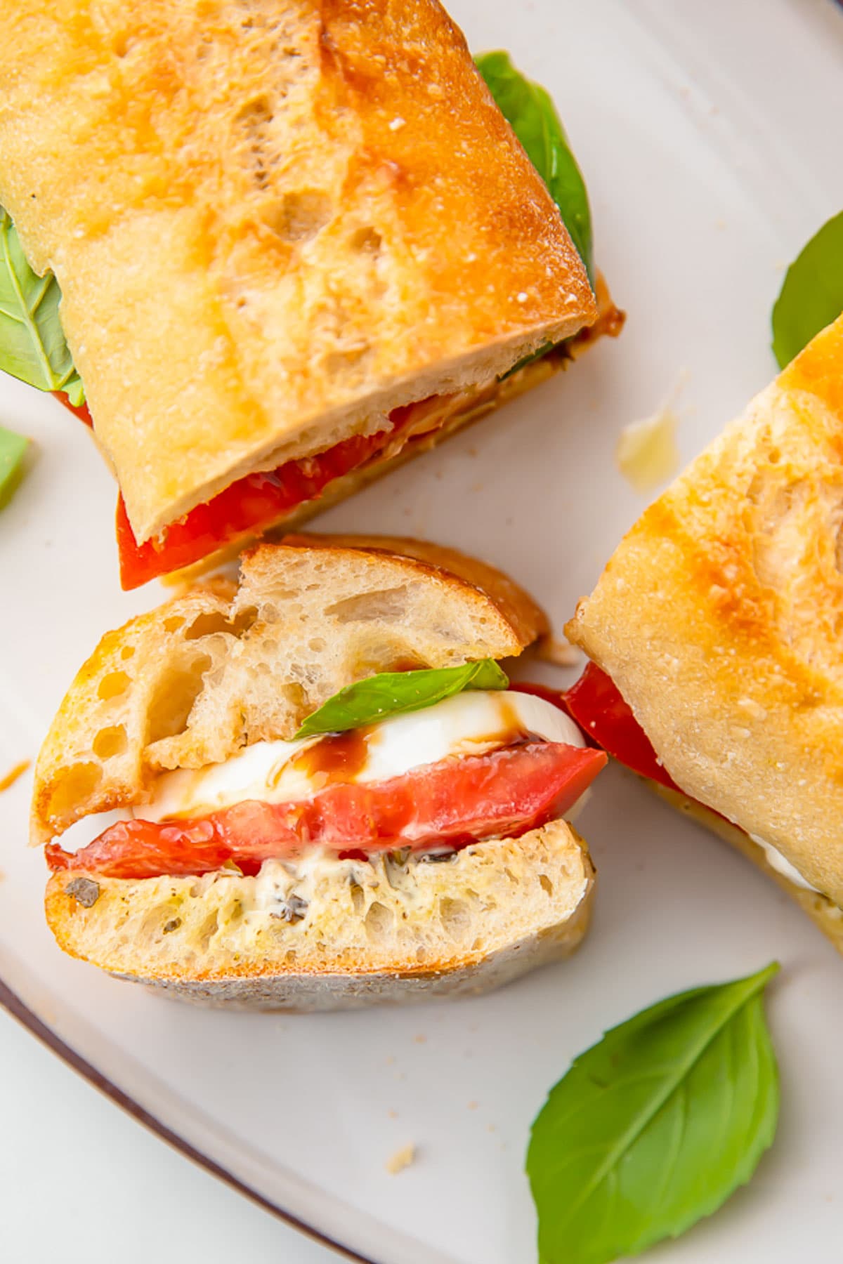 A cross section of a caprese sandwich, stood upright on one end to show the inside of the sandwich.