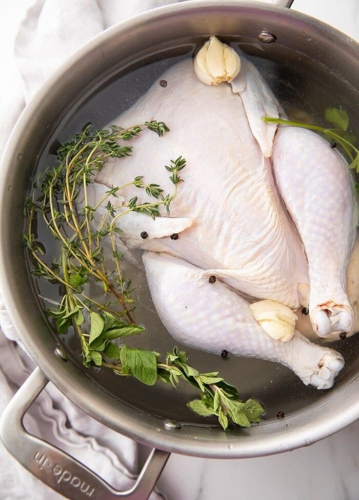 A whole chicken in a pot of brine