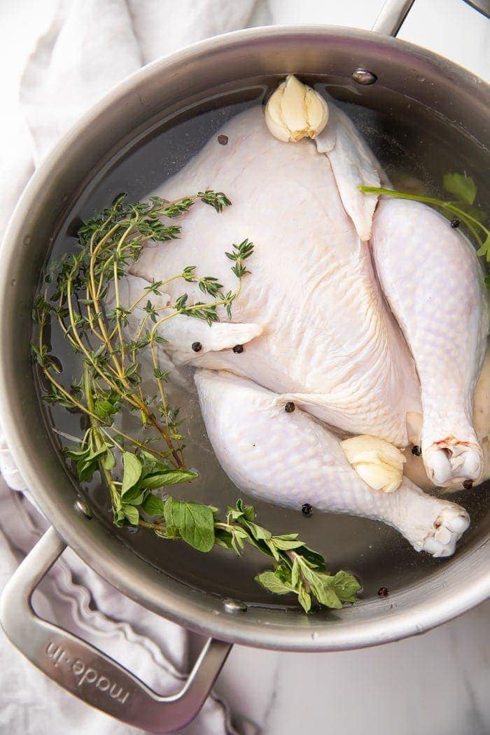 A whole chicken in a pot of brine