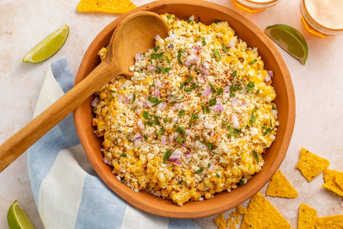 Top-down photo of a large wooden bowl holding a Mexican street corn salad.