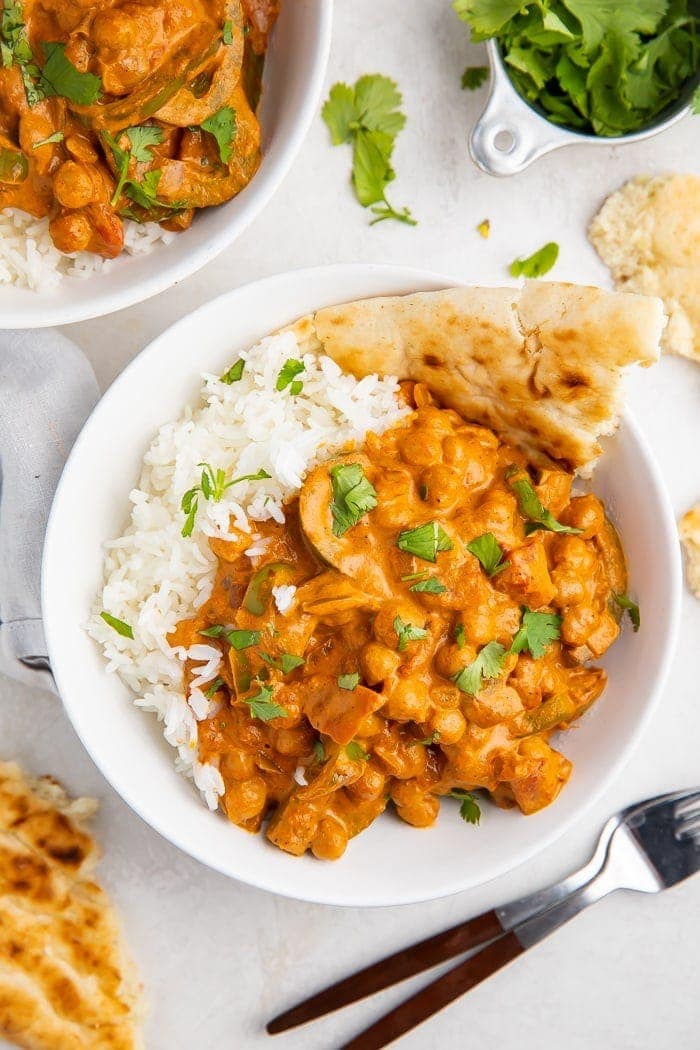 Bowls of chickpea tikka masala with naan