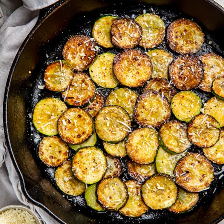 Crispy sauteed zucchini discs topped with finely shredded cheese.