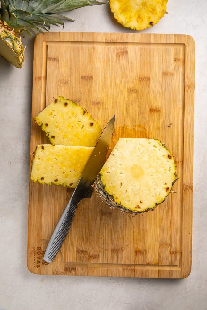 Cutting the skin off a pineapple