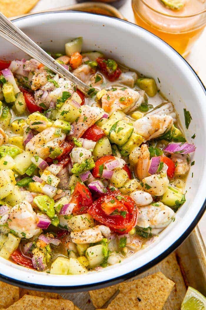 Shrimp ceviche in a bowl with chips and a beer