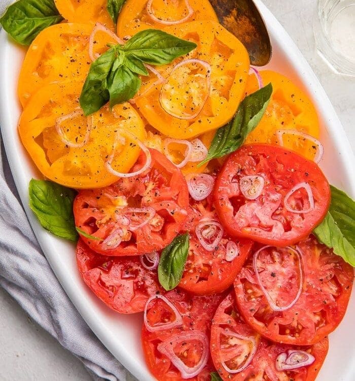 Slices of red and yellow heirloom tomatoes on a serving plate