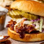 Sandwich with Instant Pot BBQ chicken topped with coleslaw