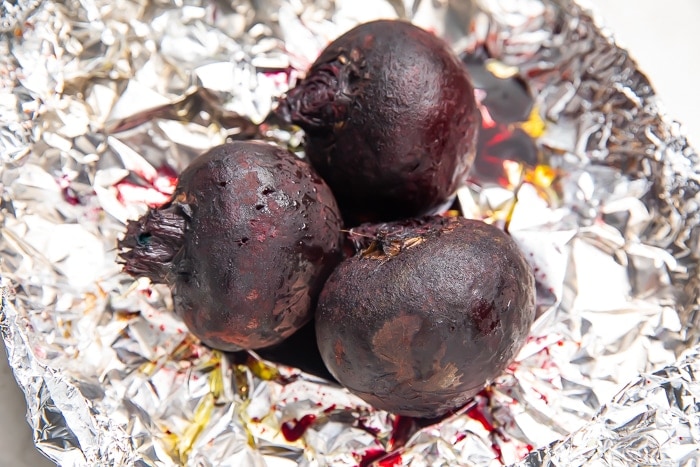 Whole roasted beets on sheet of aluminum foil