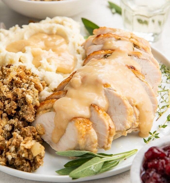 Instant Pot turkey breast slices covered with gravy on a plate