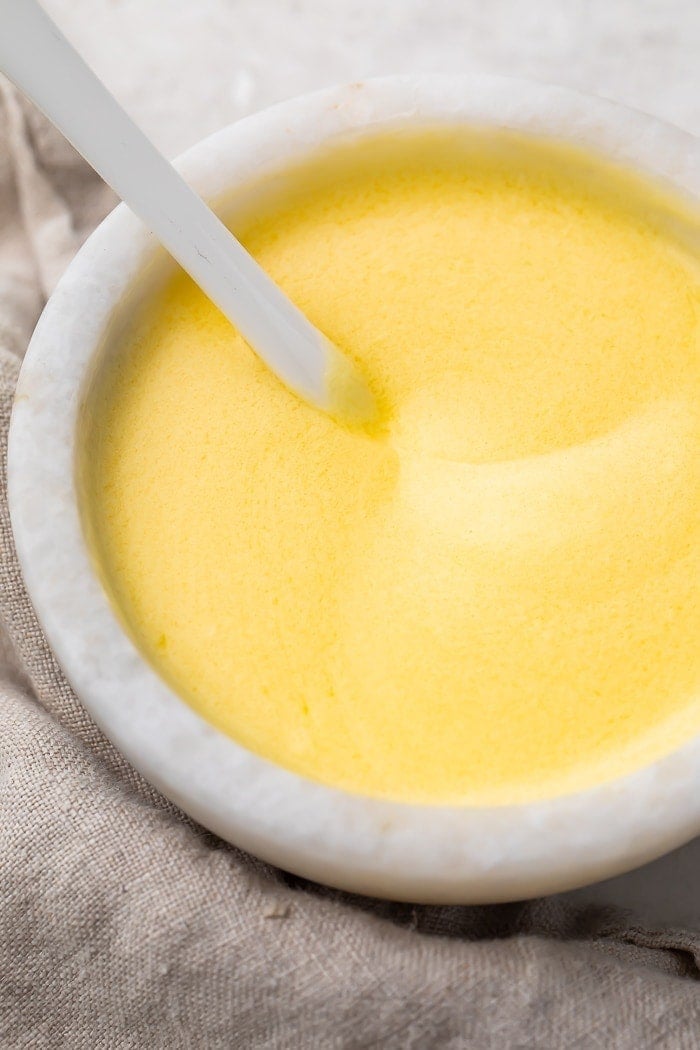 Buttery hollandaise sauce in a white ramekin dish