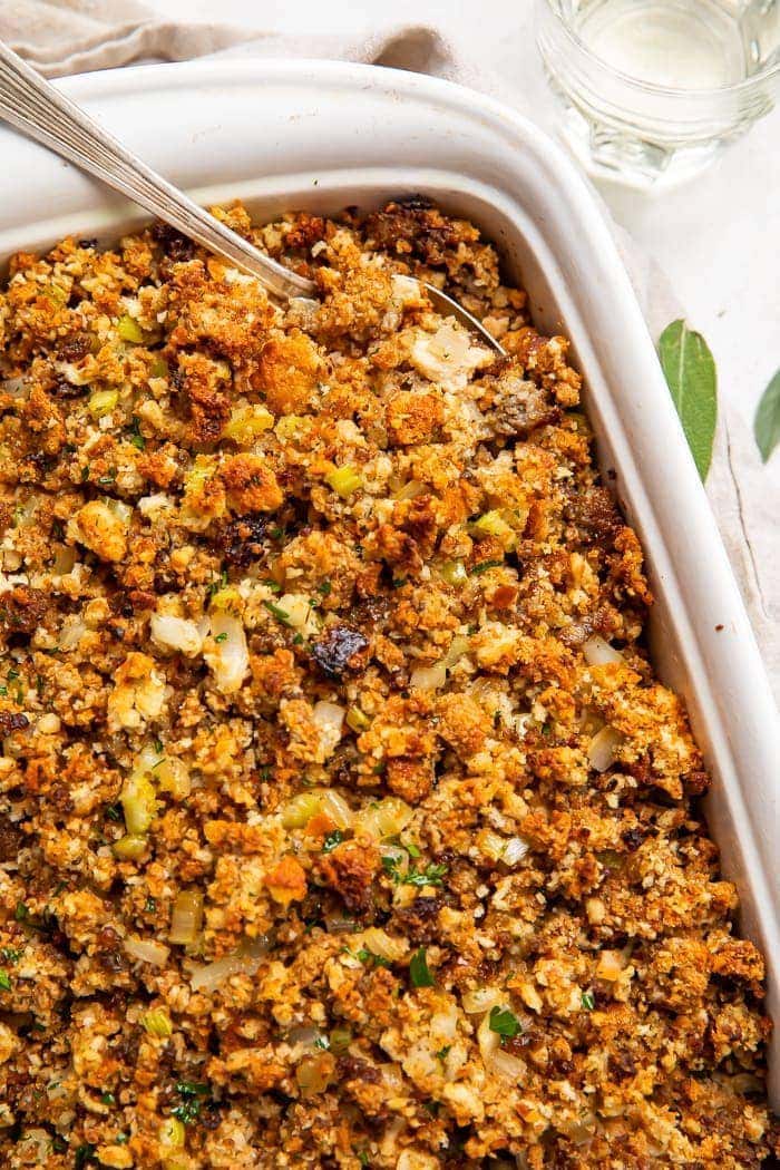 Sausage stuffing in a white baking dish with a spoon