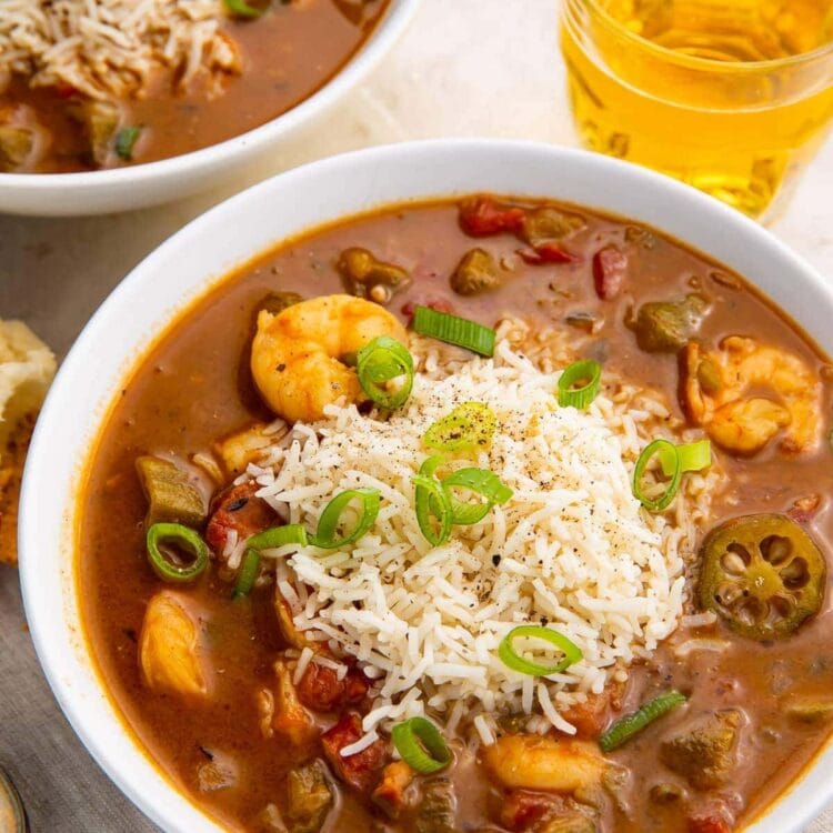Two bowls of shrimp and andouille gumbo on a white background