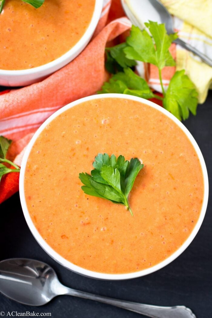 A bowl of creamy tomato soup garnished with parsley