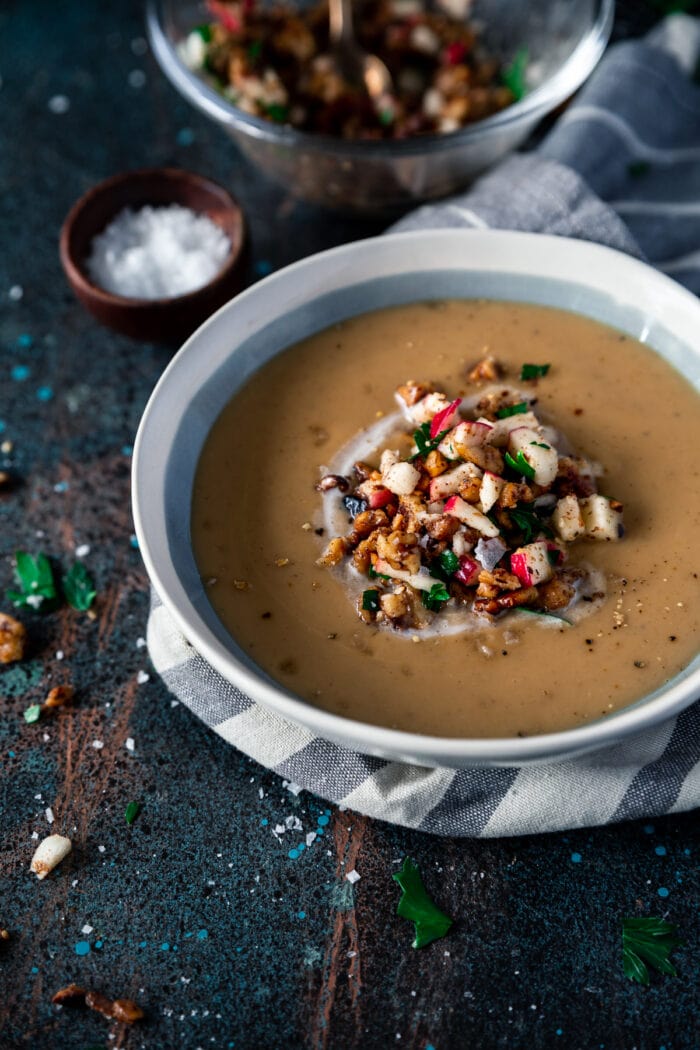 A white and blue bowl of dark Moroccan spiced parsnip soup