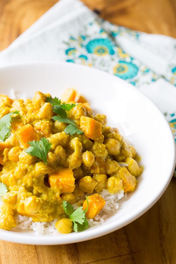 Vegetarian slow cooker chickpea curry recipe in a white bowl on a wooden table