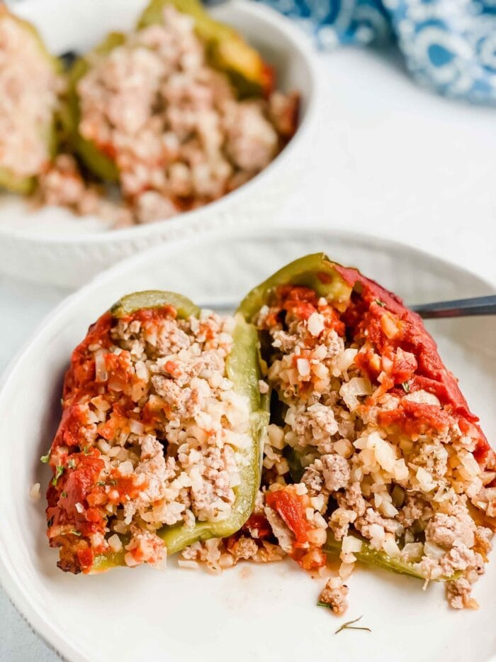 Pork and cauliflower rice stuffed peppers on a white plate
