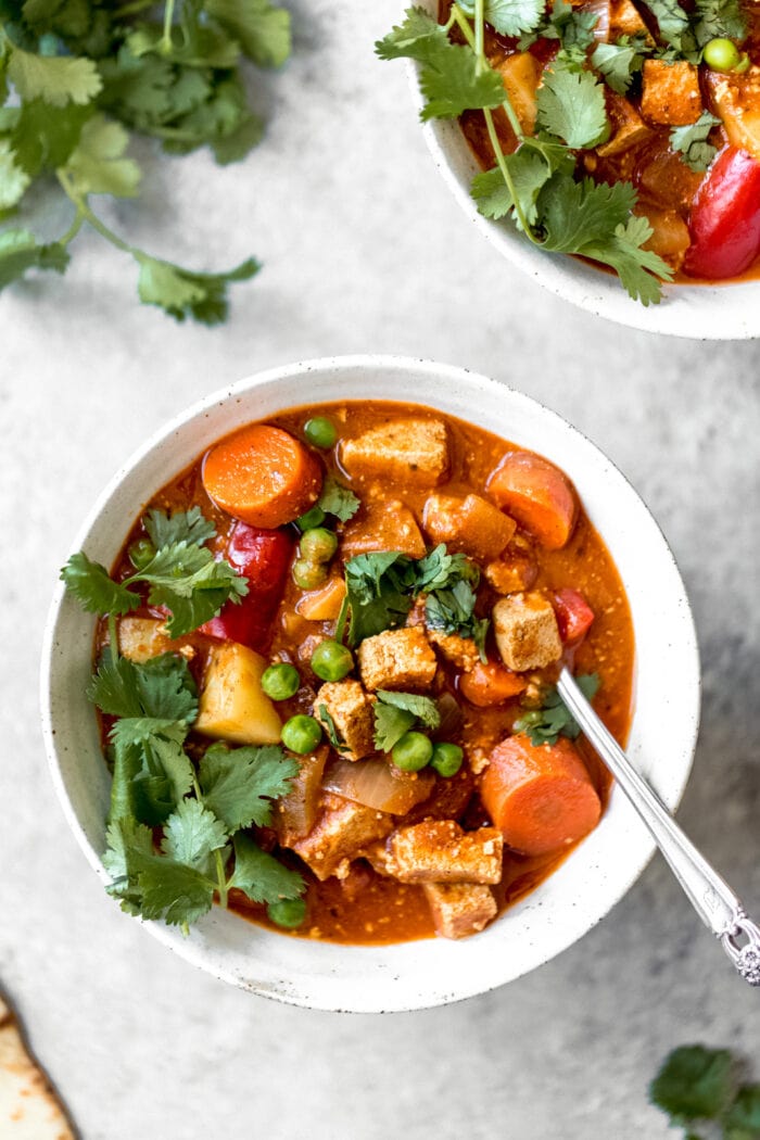 A white bowl of vegan tikka masala slow cooker stew