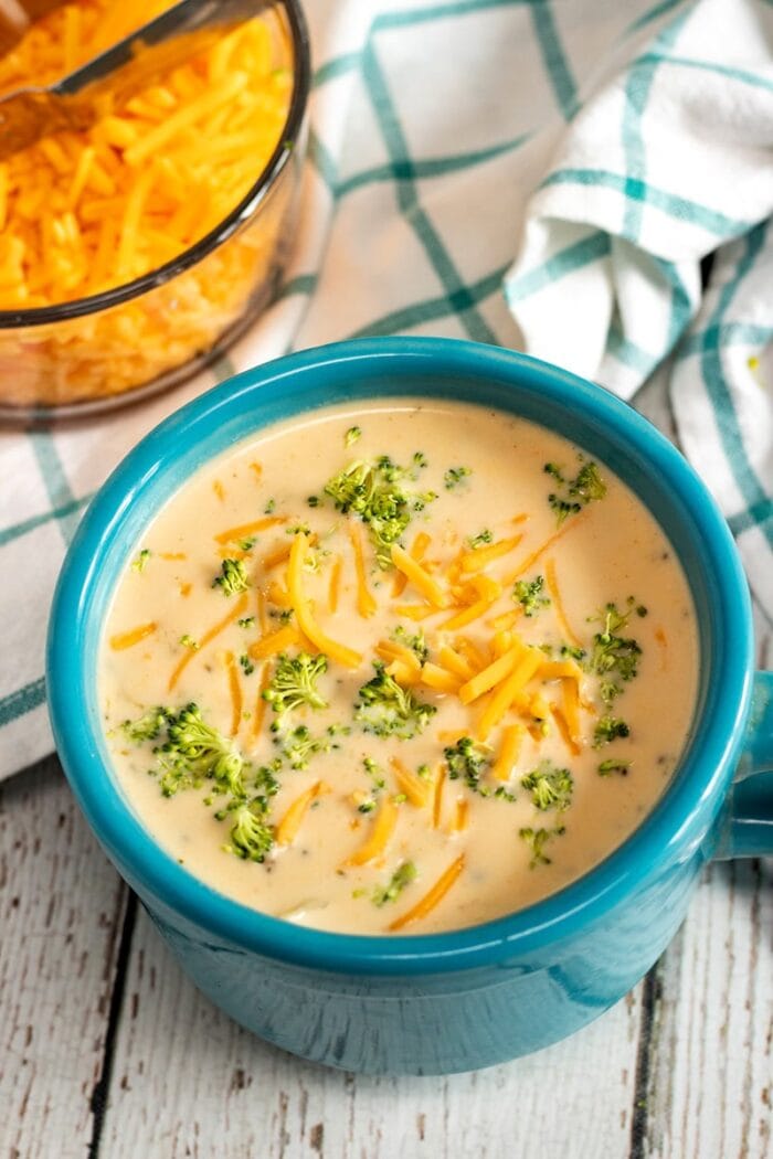 Blue bowl holding yellow creamy broccoli cheddar vegetarian Instant Pot soup