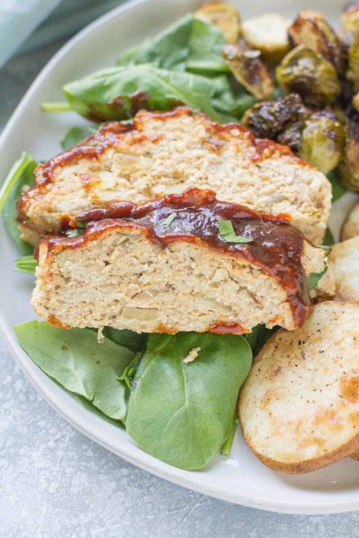 Whole30 barbecue chicken meatloaf with greens on a white plate