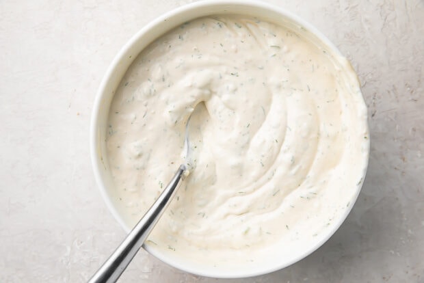 Finished horseradish sauce in a white bowl with a silver spoon