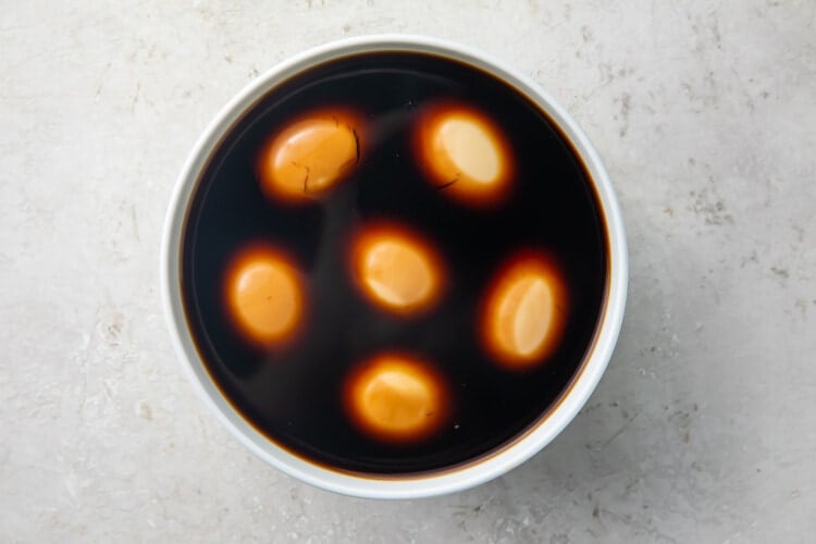 Soft boiled eggs marinating in a keto ramen marinade