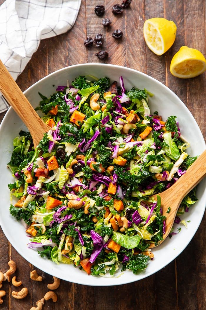 Rainbow veggie salad in a skillet with two wooden spoons