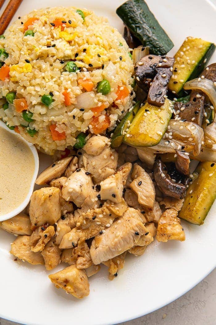 Close up photo of whole30 hibachi chicken, rice, and veggies on a white plate
